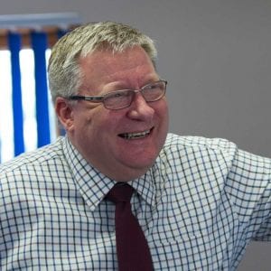 Martin Ross Mortgage Adviser standing and smiling whilst wearing his tie