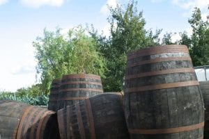 Aged Wooden Cider Barrels in Front of apple orchard Somerset 1st Financial Group Somerset Advisers